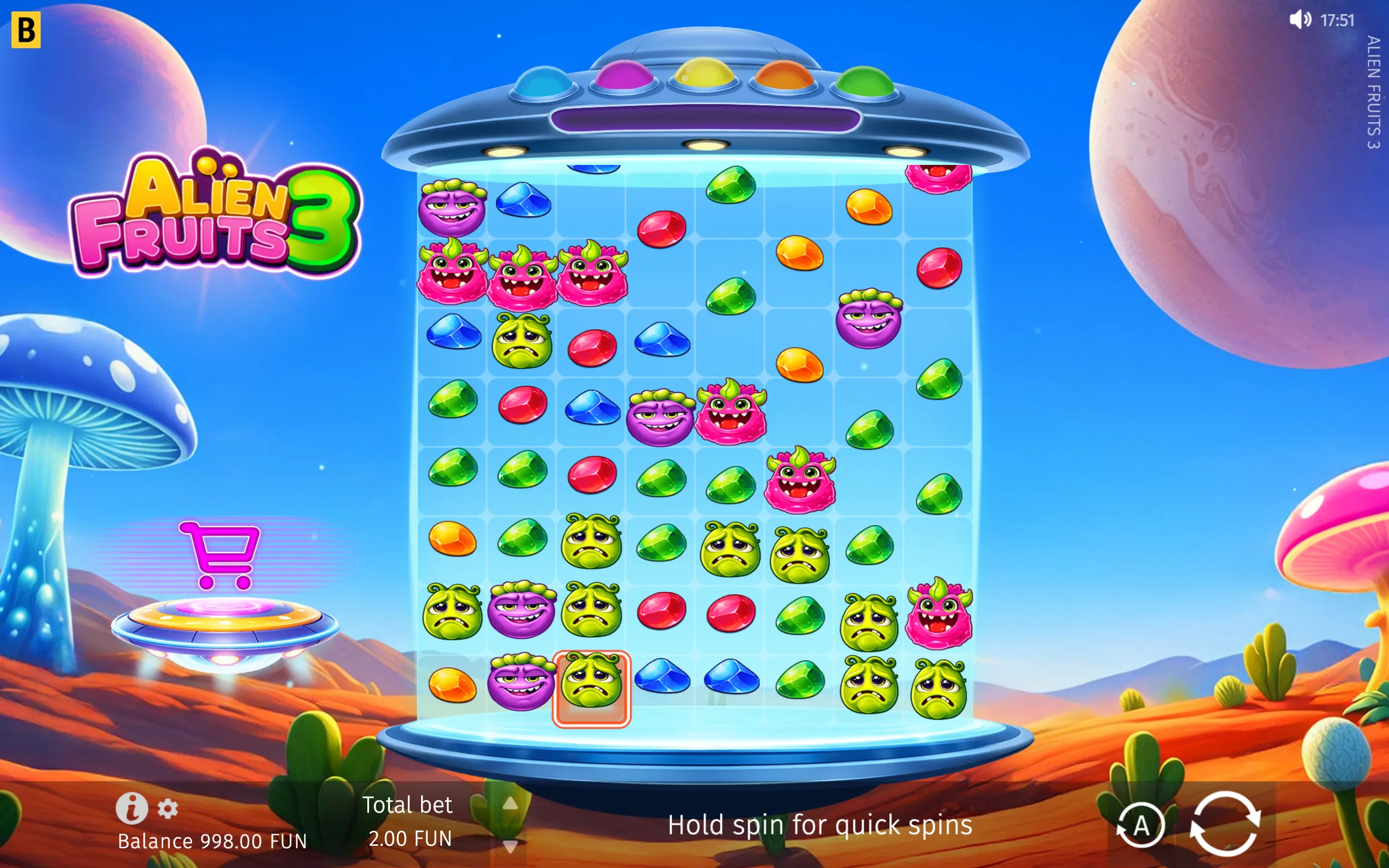 Colorful Alien Fruits 3 slot game with a cartoon UFO, smiling alien fruit symbols, jewel-like fruit icons, and a vivid extraterrestrial desert with planets and mushrooms.