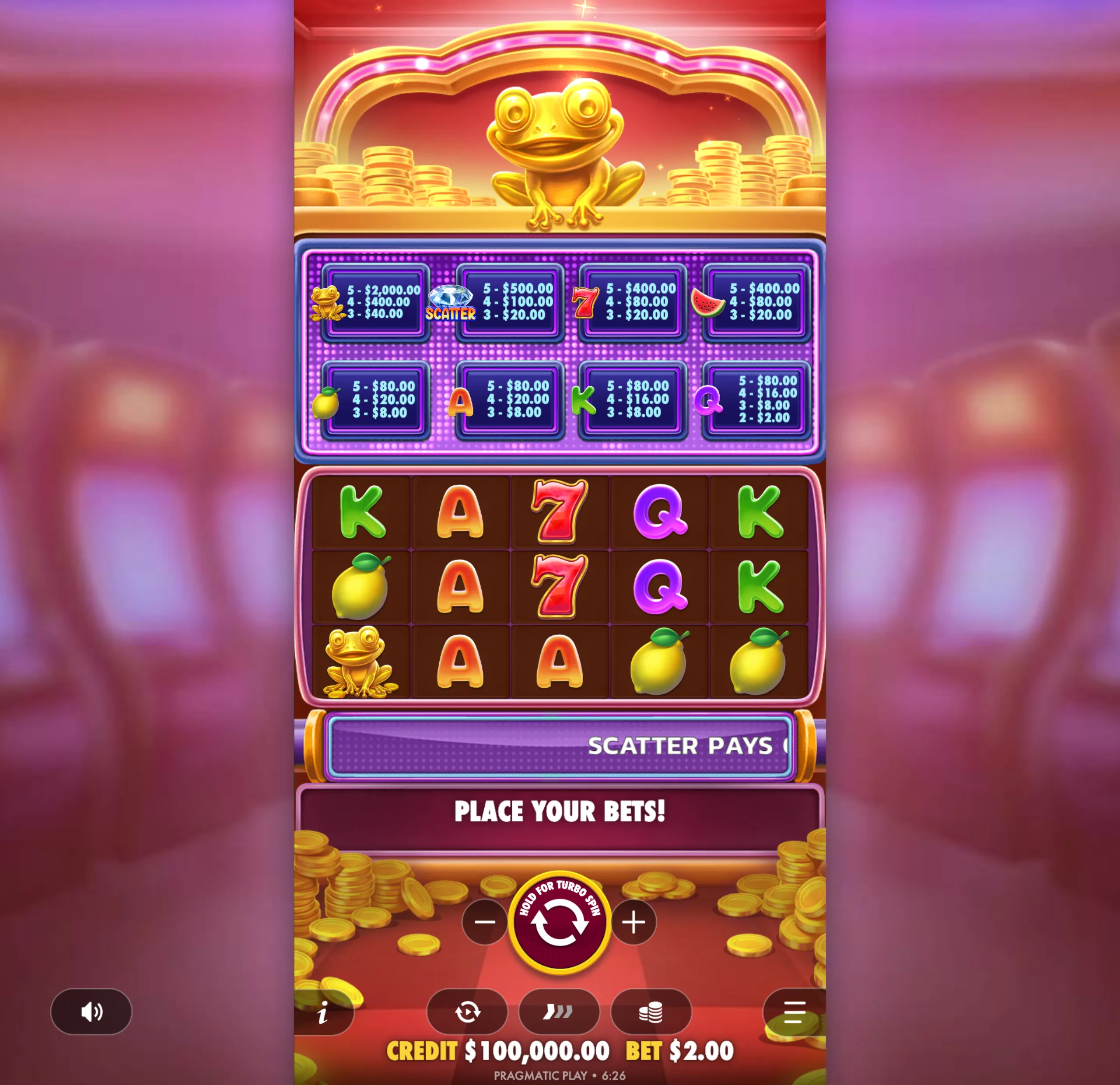 Bright and colorful slot game interface featuring a golden frog symbol, various fruit and classic slot icons, and a payout table with values for different symbol combinations.
