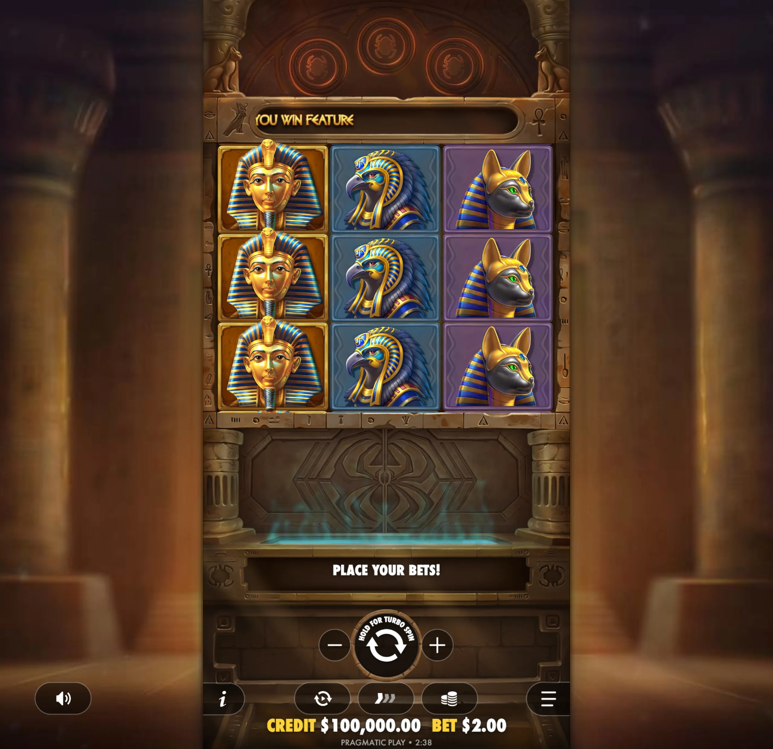 Ancient Egyptian-themed slot game interface featuring symbols of a pharaoh, falcon, and jackal heads with a 'You Win Feature' message and a bet control panel.