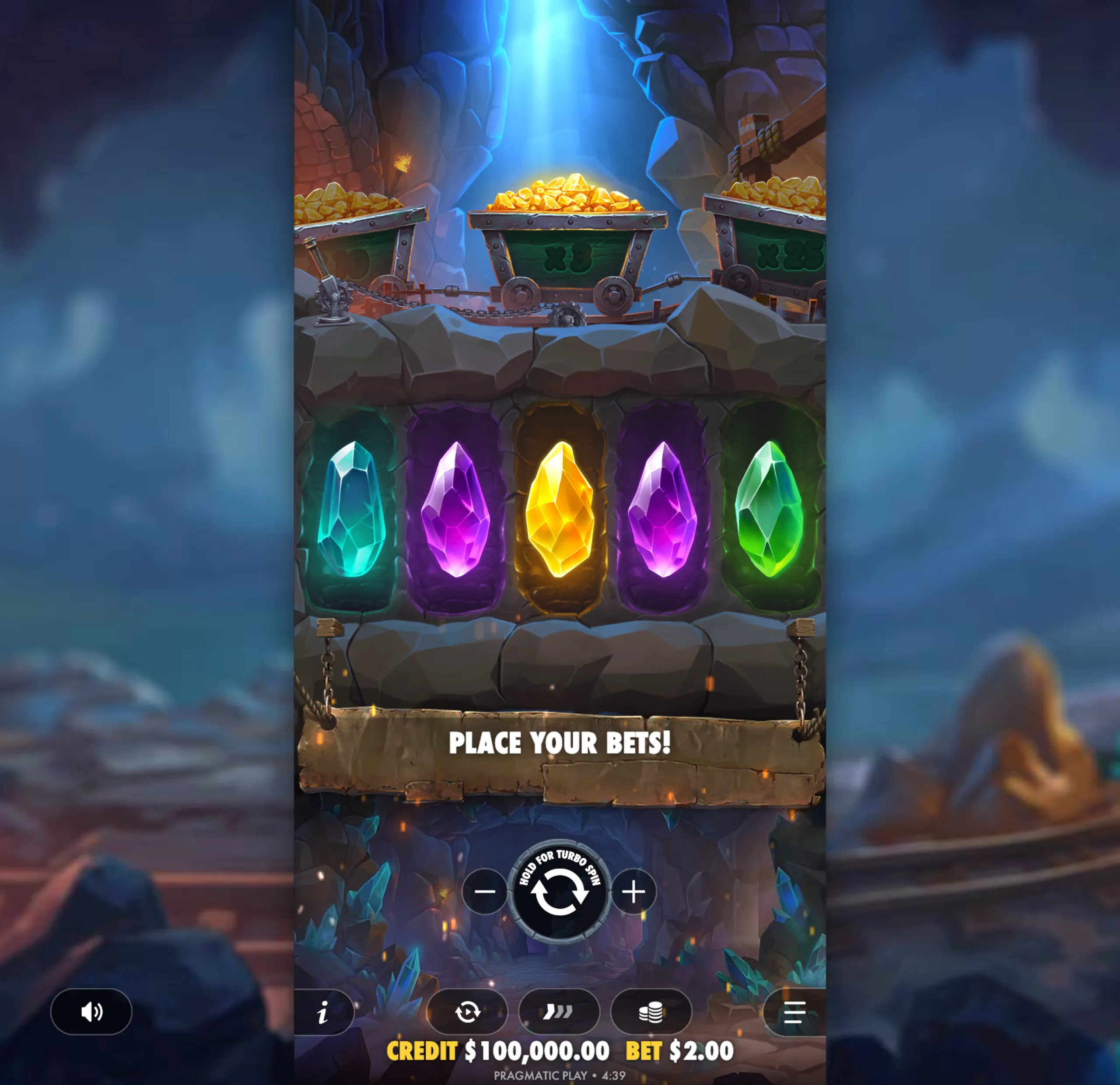 A mining-themed slot game interface featuring colorful glowing gems and carts filled with gold nuggets inside a rocky cave.