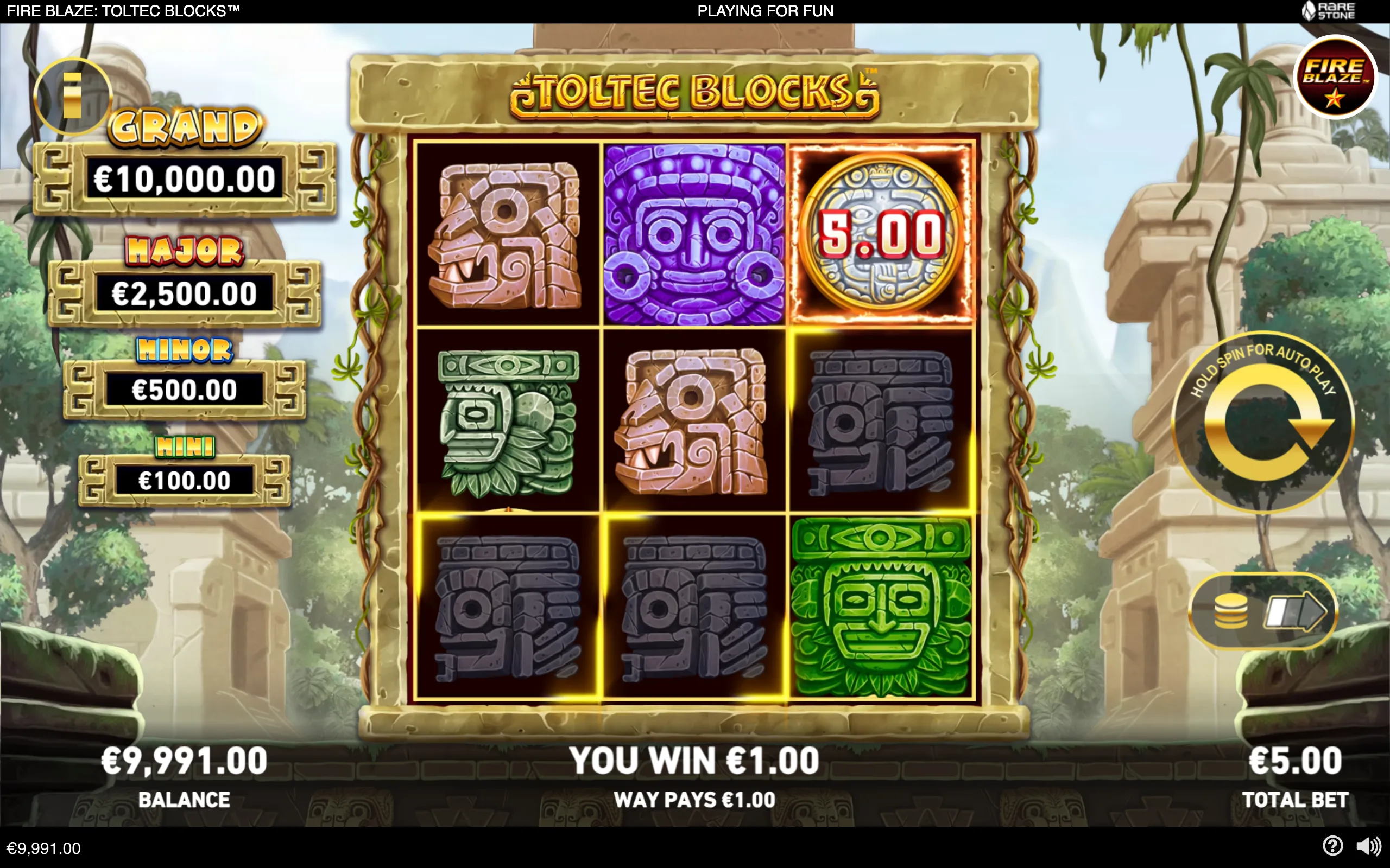 Fire Blaze Toltec Blocks slot interface with a 3x3 grid of colorful carved stone masks, a €5.00 coin symbol, jackpot values, and an ancient jungle temple backdrop.