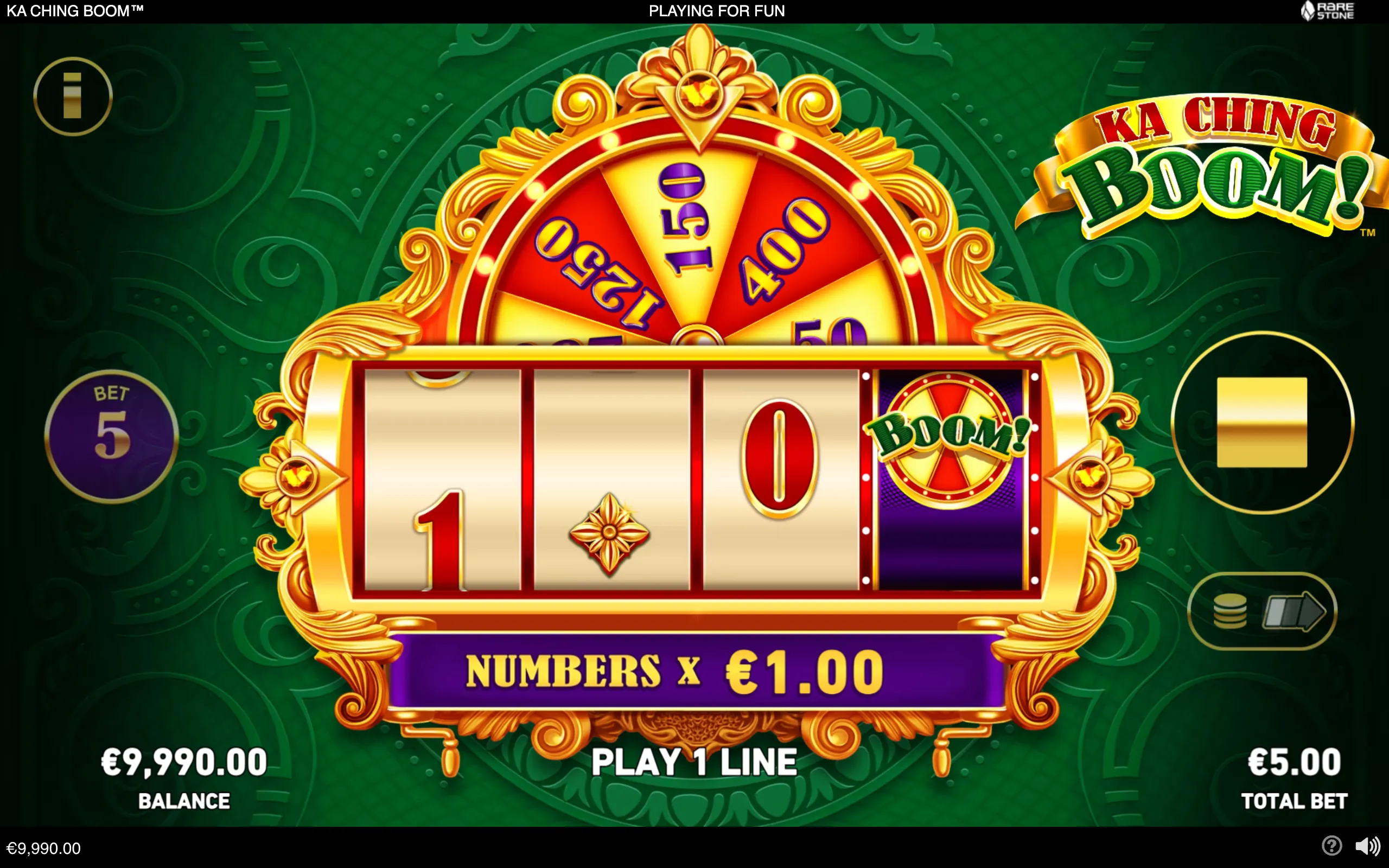 Ka Ching Boom slot interface with ornate gold trim, three number reels, a Boom! wheel symbol, and a large prize wheel against a dark green patterned backdrop.