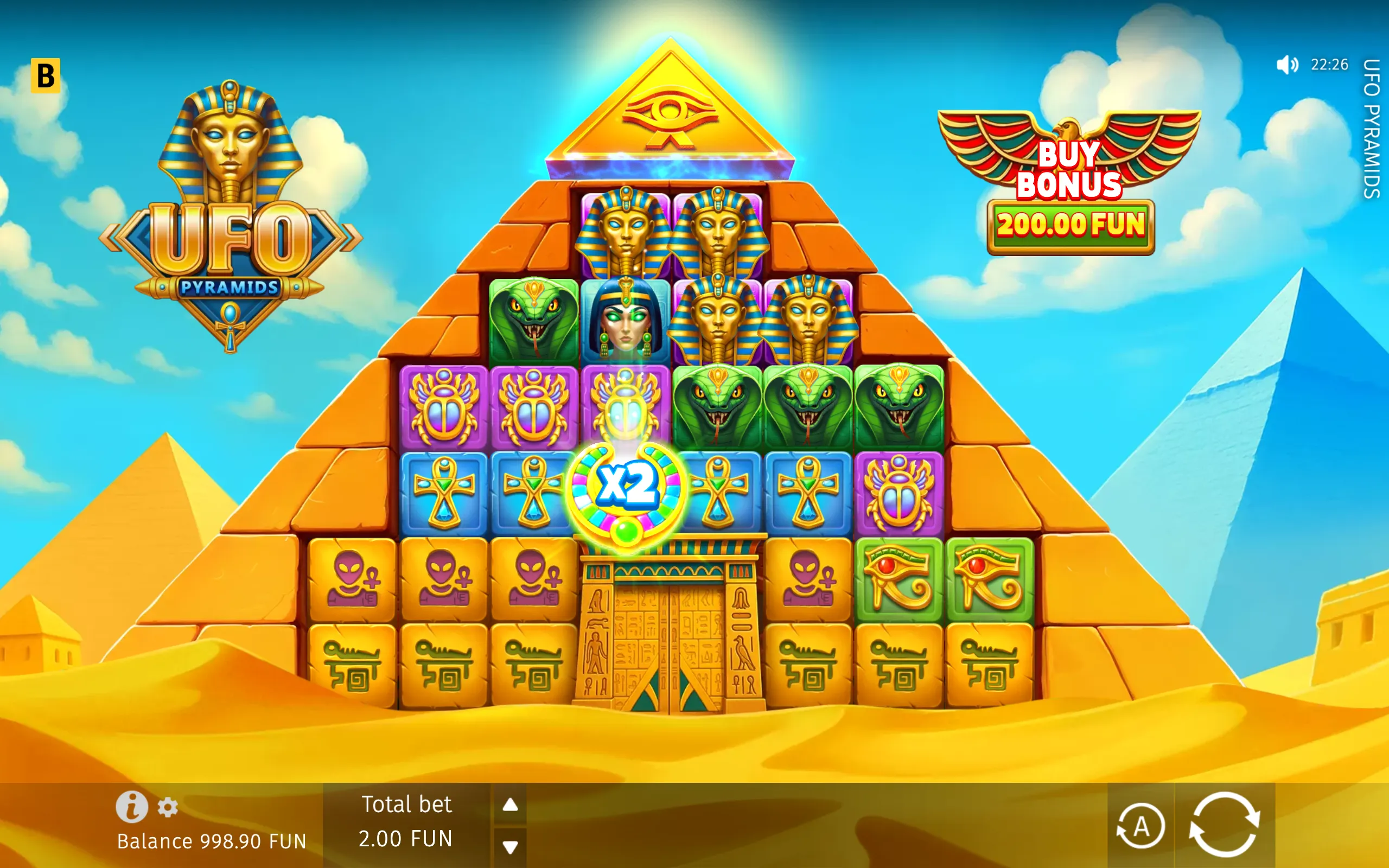 UFO Pyramids slot game with Egyptian pharaohs, cobra and scarab symbols, a glowing x2 multiplier, desert pyramids, and a Buy Bonus option.