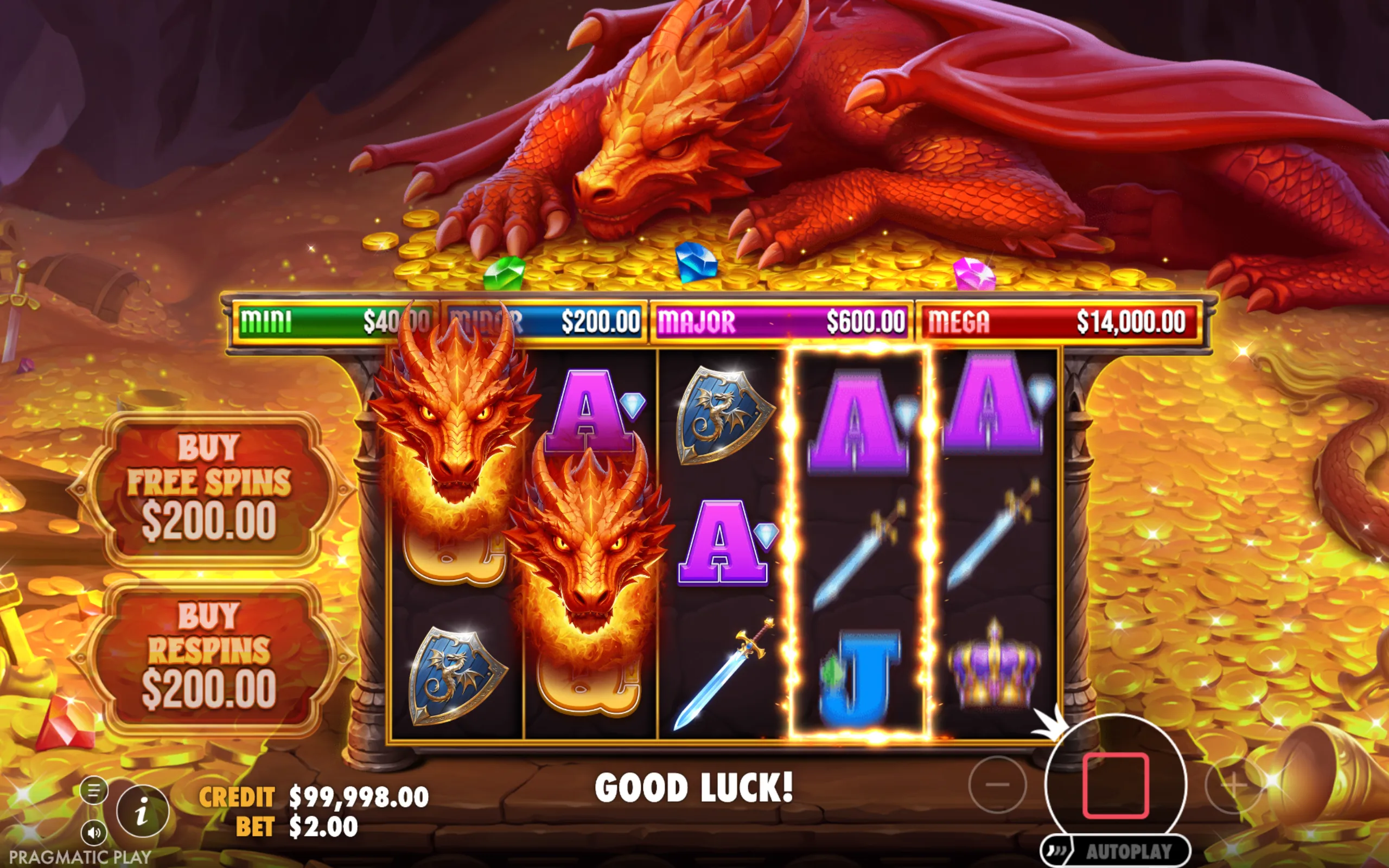 A red dragon sleeps atop a pile of gold coins and colorful gems in a treasure cave, with slot reels featuring dragon heads, swords, shields, and royal symbols, alongside jackpot tiers and buy feature options.